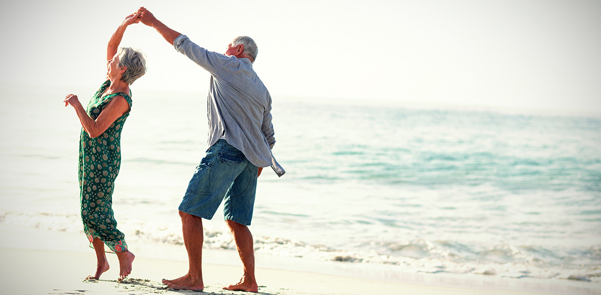 Senior couple dancing at beach