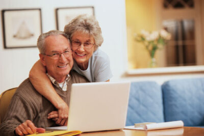 Seniors on laptop managing their wealth