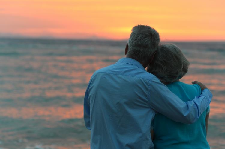 Senior couple watching the sunset at the beach